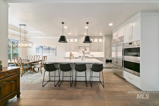 kitchen with stainless steel appliances, a breakfast bar area, white cabinets, and ornamental molding