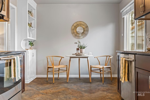 dining area with stone finish floor and baseboards