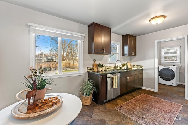 kitchen with a sink, dark countertops, stainless steel dishwasher, dark brown cabinetry, and washer / dryer