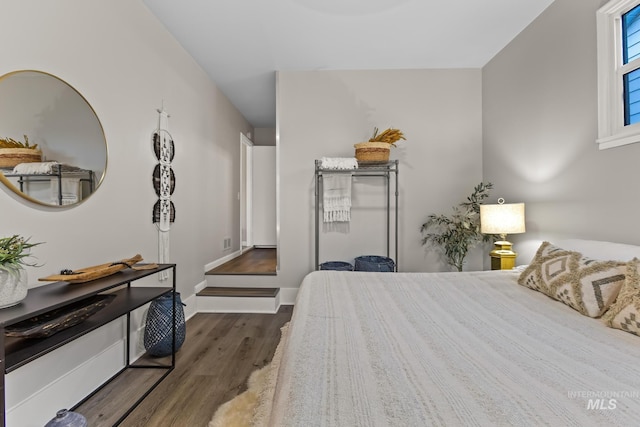 bedroom with baseboards and wood finished floors