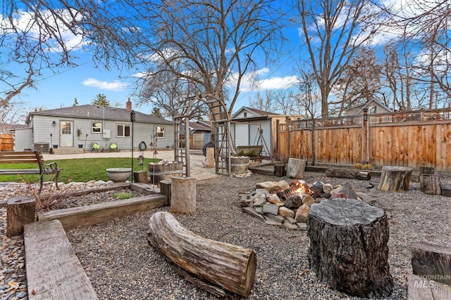 view of yard with an outbuilding, central AC unit, a fenced backyard, and a garden