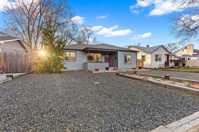 view of front of home with fence and a shingled roof