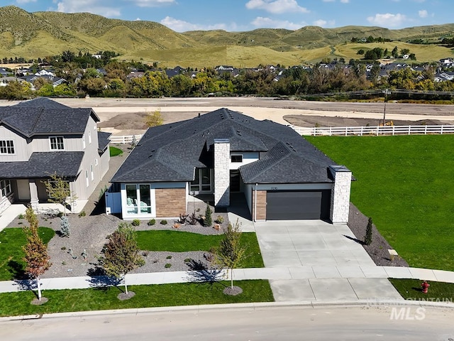 view of front of house with a garage, a mountain view, and a front lawn