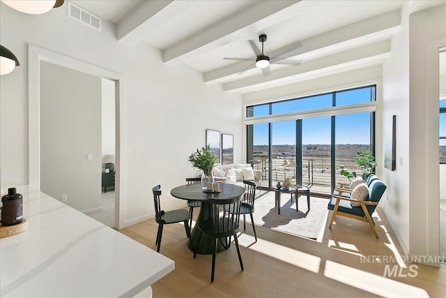 dining space featuring visible vents, baseboards, ceiling fan, beamed ceiling, and light wood-type flooring