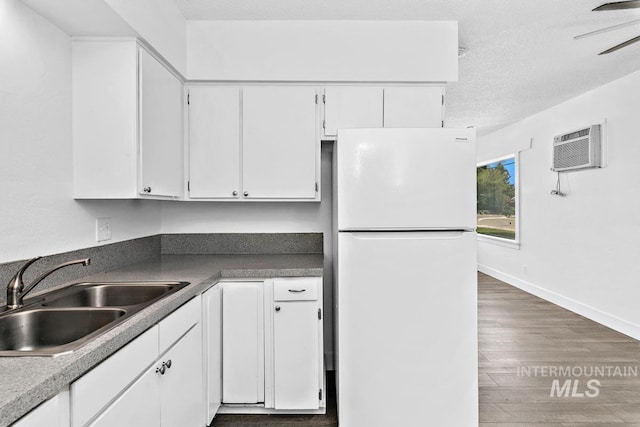 135 Davis Ave, Nampa, ID 83651 - kitchen featuring freestanding refrigerator, a sink, white cabinetry, a wall mounted air conditioner, and wood finished floors