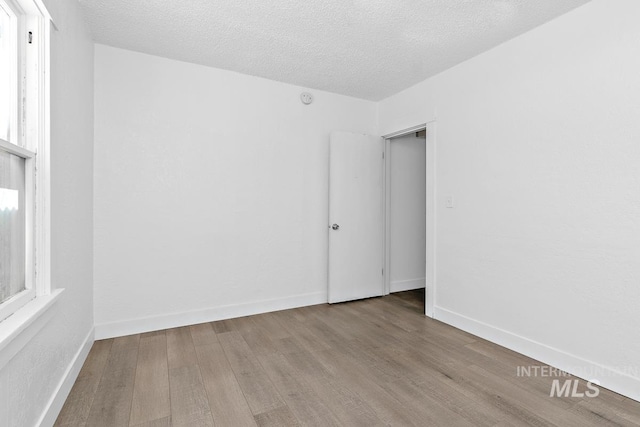 135 Davis Ave, Nampa, ID 83651 - empty room featuring wood finished floors, a textured ceiling, baseboards, and plenty of natural light