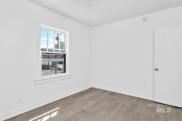 135 Davis Ave, Nampa, ID 83651 - empty room with wood finished floors, a textured ceiling, and baseboards