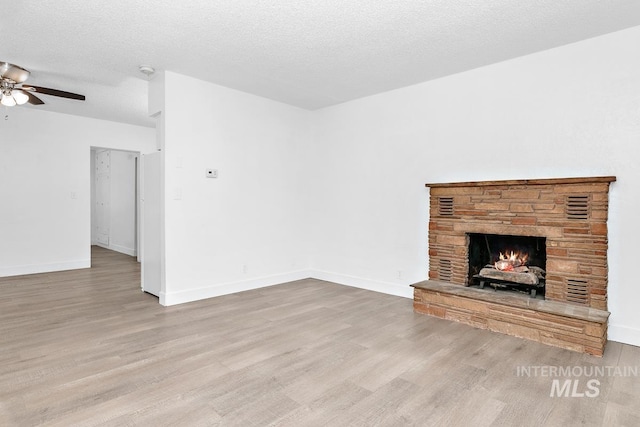 135 Davis Ave, Nampa, ID 83651 - unfurnished living room featuring wood finished floors, a ceiling fan, a fireplace, and baseboards