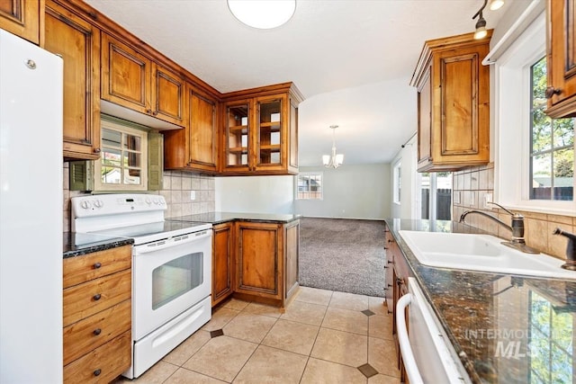 kitchen with white appliances, light tile patterned flooring, sink, backsplash, and a chandelier