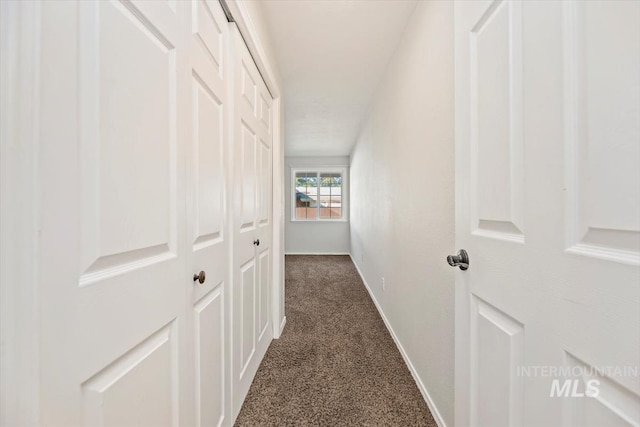 hallway with dark colored carpet