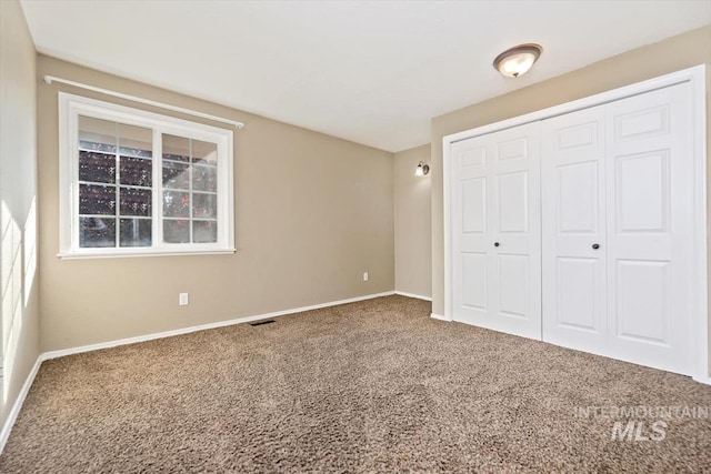 unfurnished bedroom with a closet and carpet floors