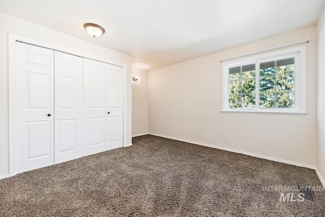 unfurnished bedroom with carpet flooring and a closet