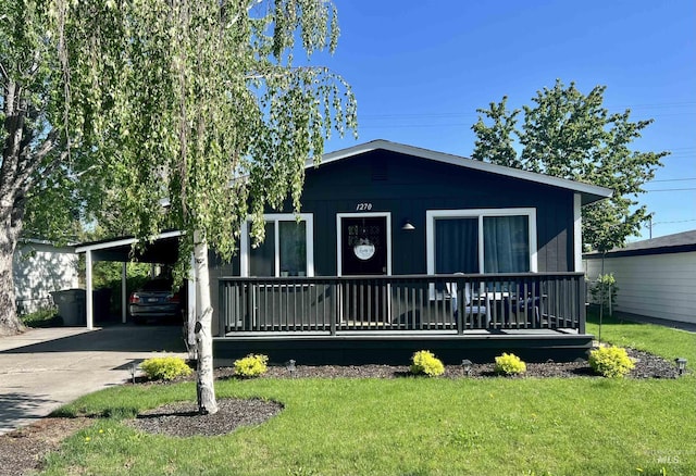 view of front of home featuring a carport, a front yard, and driveway