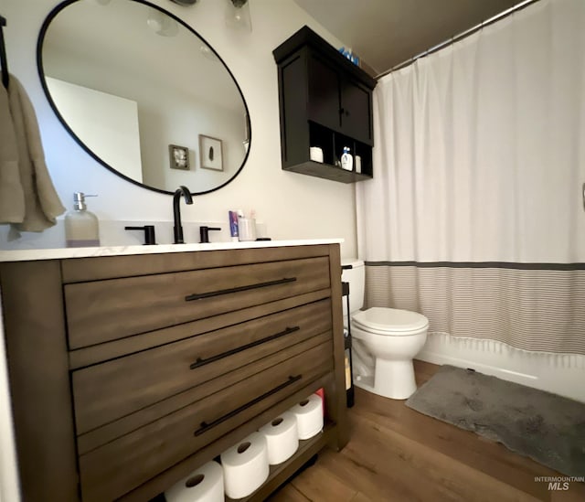 bathroom featuring vanity, wood finished floors, and toilet