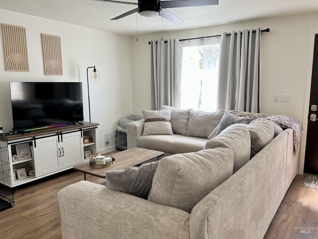 living area featuring a textured ceiling, ceiling fan, and dark wood-type flooring