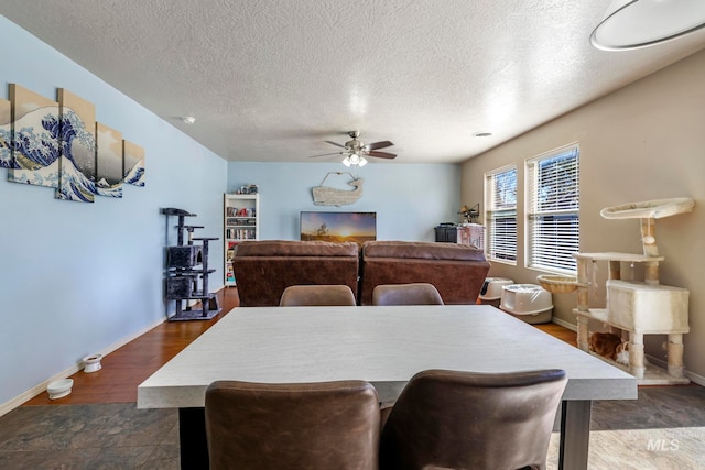 dining room with ceiling fan, a textured ceiling, and dark wood-type flooring