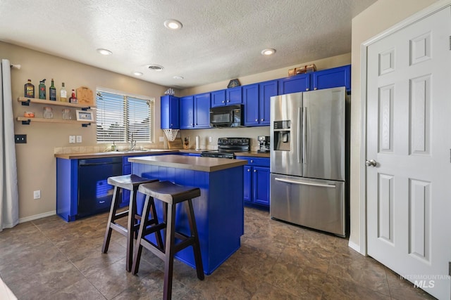 kitchen with blue cabinetry, a breakfast bar area, a kitchen island, and black appliances