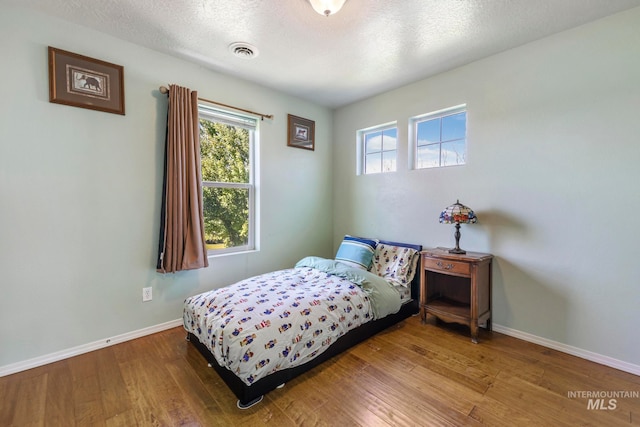 bedroom featuring a textured ceiling and hardwood / wood-style floors