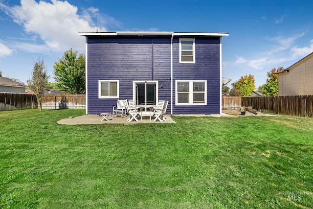 rear view of property with a yard and a patio area