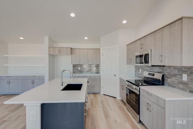 kitchen featuring light countertops, light wood finished floors, appliances with stainless steel finishes, and a sink