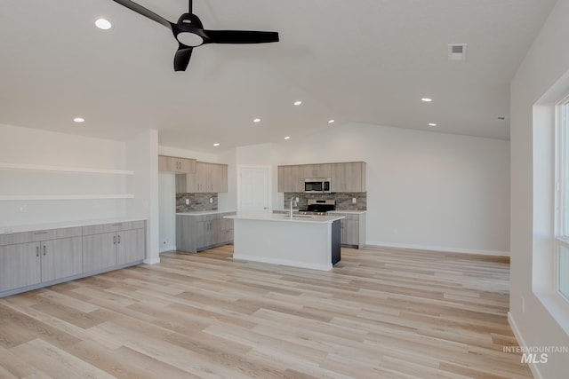 kitchen featuring light brown cabinets, appliances with stainless steel finishes, light countertops, ceiling fan, and vaulted ceiling