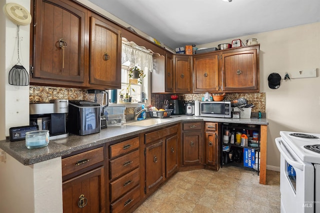 1817 Granada Dr, Twin Falls, ID 83301 - kitchen featuring tasteful backsplash, stainless steel microwave, a sink, white range with electric stovetop, and dark countertops