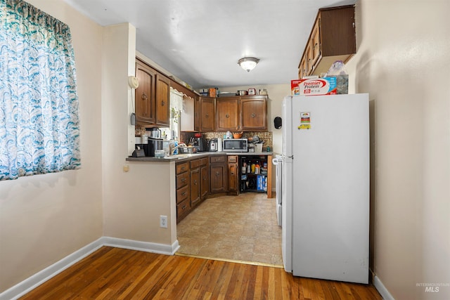 1817 Granada Dr, Twin Falls, ID 83301 - kitchen featuring stainless steel microwave, baseboards, freestanding refrigerator, light wood-style floors, and a sink