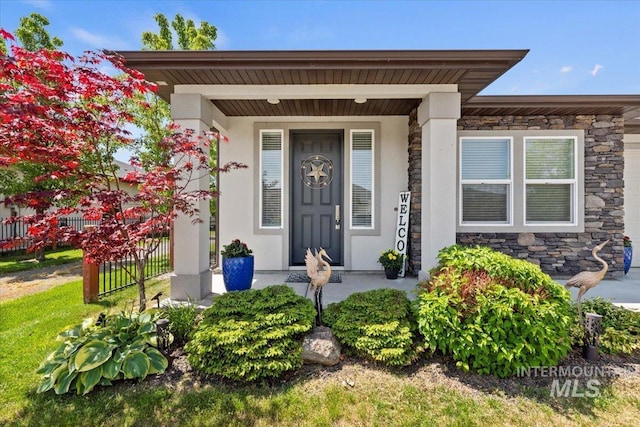 9753 W Wildbranch, Star, ID 83669 - doorway to property featuring stone siding, stucco siding, and covered porch