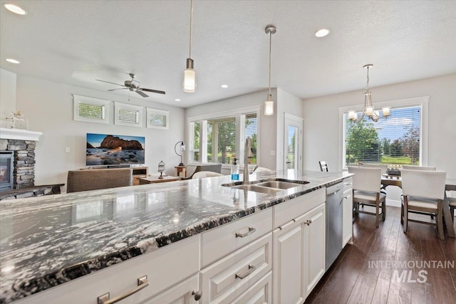 9753 W Wildbranch, Star, ID 83669 - kitchen featuring dishwasher, a chandelier, a ceiling fan, dark stone counters, and white cabinetry