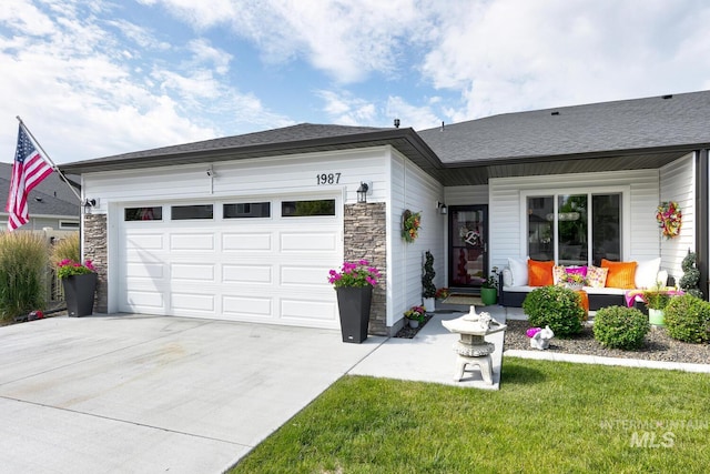 1987 S Defio Way, Meridian, ID 83642 - view of front of home with concrete driveway, a garage, stone siding, and outdoor lounge area