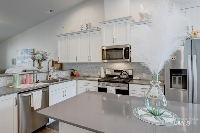 1987 S Defio Way, Meridian, ID 83642 - kitchen featuring stainless steel appliances, lofted ceiling, backsplash, white cabinets, and dark countertops