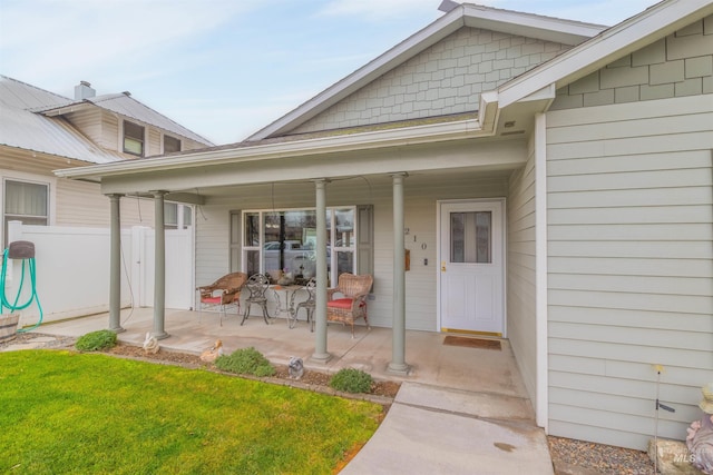 doorway to property with covered porch and a lawn