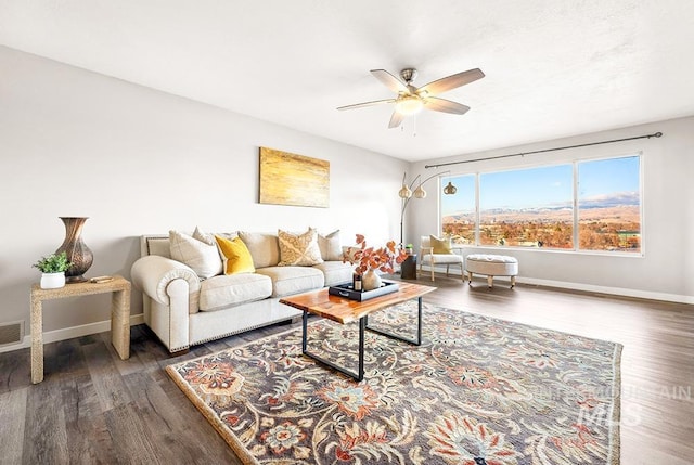 living room featuring ceiling fan and dark hardwood / wood-style floors