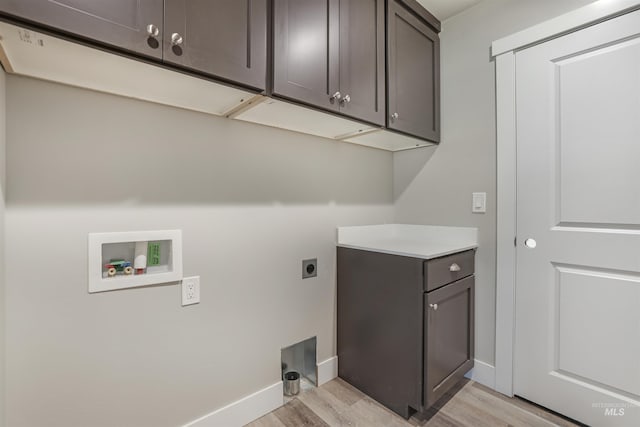 washroom featuring washer hookup, cabinets, electric dryer hookup, and light wood-type flooring