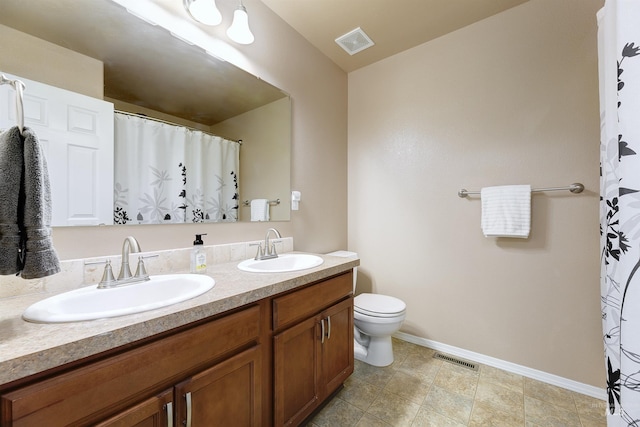 5375 N Isla Ave, Meridian, ID 83646 - bathroom with double vanity, toilet, baseboards, and a shower with shower curtain