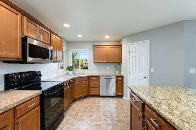 5375 N Isla Ave, Meridian, ID 83646 - kitchen with stainless steel appliances, brown cabinetry, a sink, recessed lighting, and baseboards