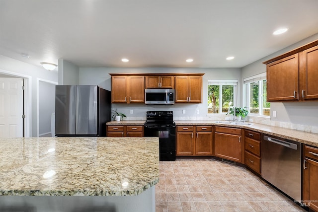 5375 N Isla Ave, Meridian, ID 83646 - kitchen featuring stainless steel appliances, a sink, brown cabinets, light stone counters, and recessed lighting