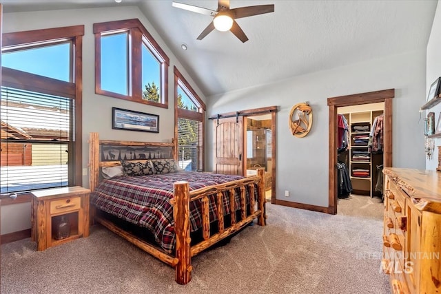 carpeted bedroom featuring ceiling fan, a walk in closet, ensuite bath, and multiple windows