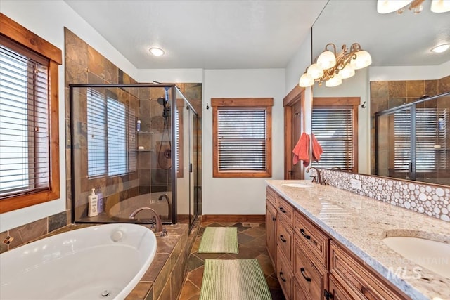 bathroom featuring a healthy amount of sunlight, plus walk in shower, and vanity