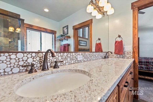 bathroom featuring vanity, an inviting chandelier, and decorative backsplash