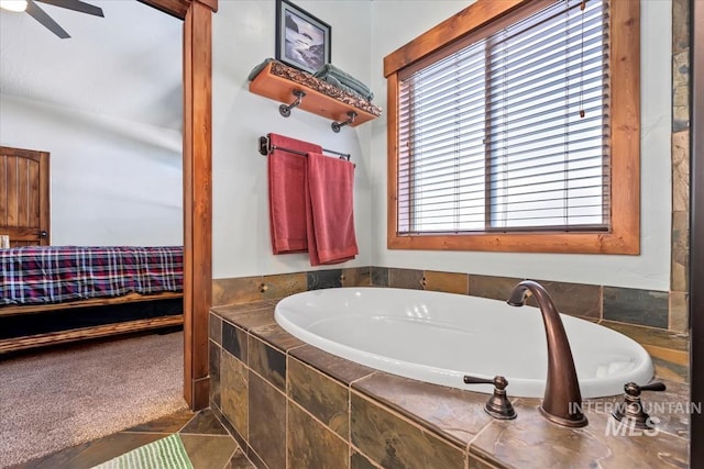 bathroom featuring tiled tub and ceiling fan