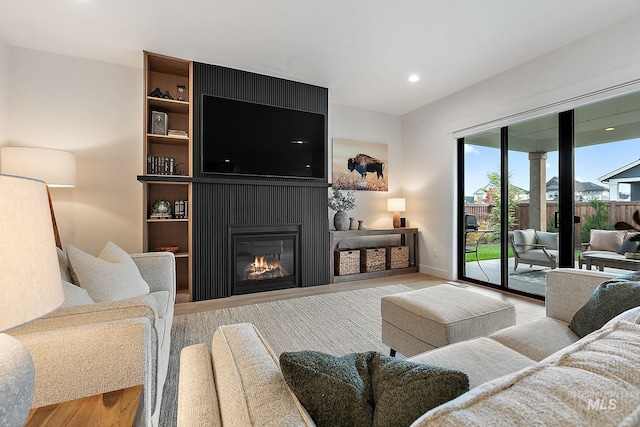 living room featuring a large fireplace and light hardwood / wood-style flooring