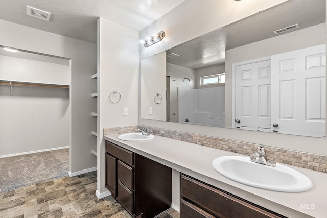 bathroom with vanity, walk in shower, backsplash, and tile patterned floors