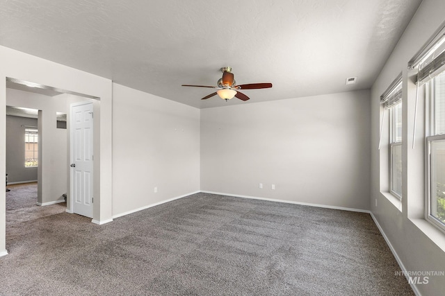 spare room featuring ceiling fan and carpet flooring