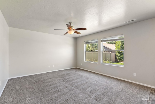 empty room with carpet flooring, a textured ceiling, and ceiling fan