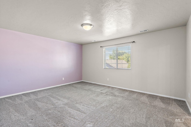 carpeted empty room featuring a textured ceiling