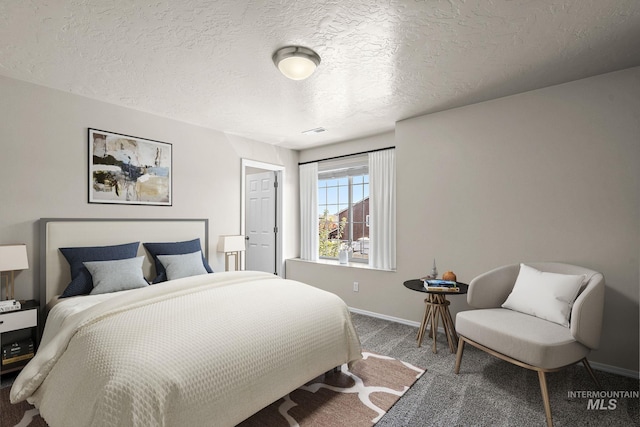 bedroom featuring dark colored carpet and a textured ceiling