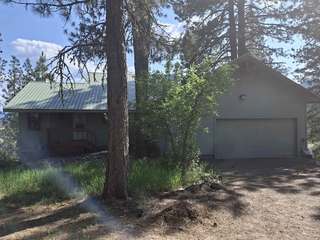 8 Lookout Rd, Garden Valley, ID 83622 - view of side of home featuring a garage, driveway, metal roof, and covered porch