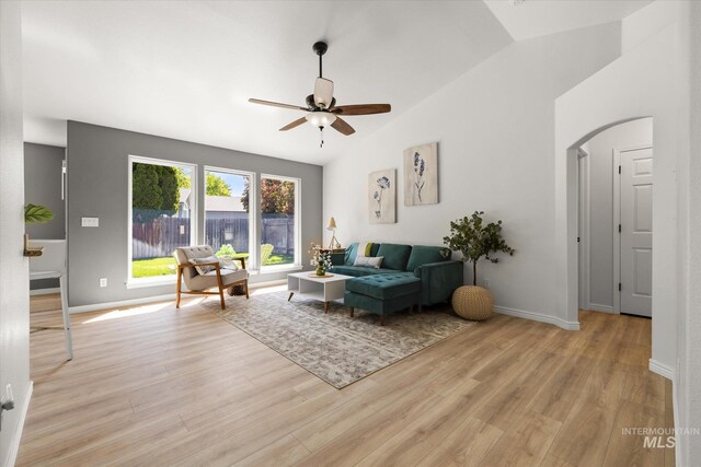 512 S Pelican Way, Meridian, ID 83642 - living room with vaulted ceiling, a ceiling fan, light wood-style floors, baseboards, and arched walkways