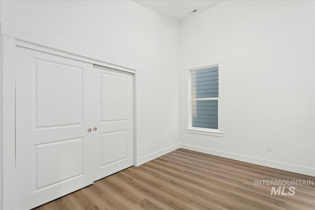 unfurnished bedroom featuring hardwood / wood-style floors and a closet